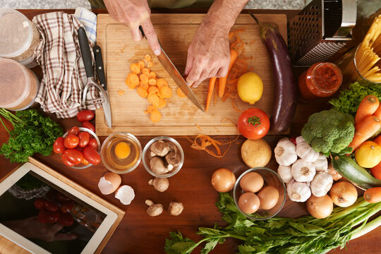 top-view-cropped-hands-senior-cook-unrecognizable-cutting-carrot-cooking-vegetable-stew.jpg